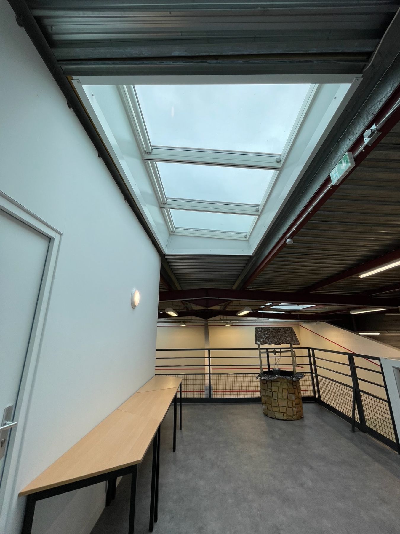 Bandeau de fenêtres de toit VELUX éclairant la mezzanine d'un bâtiment sportif