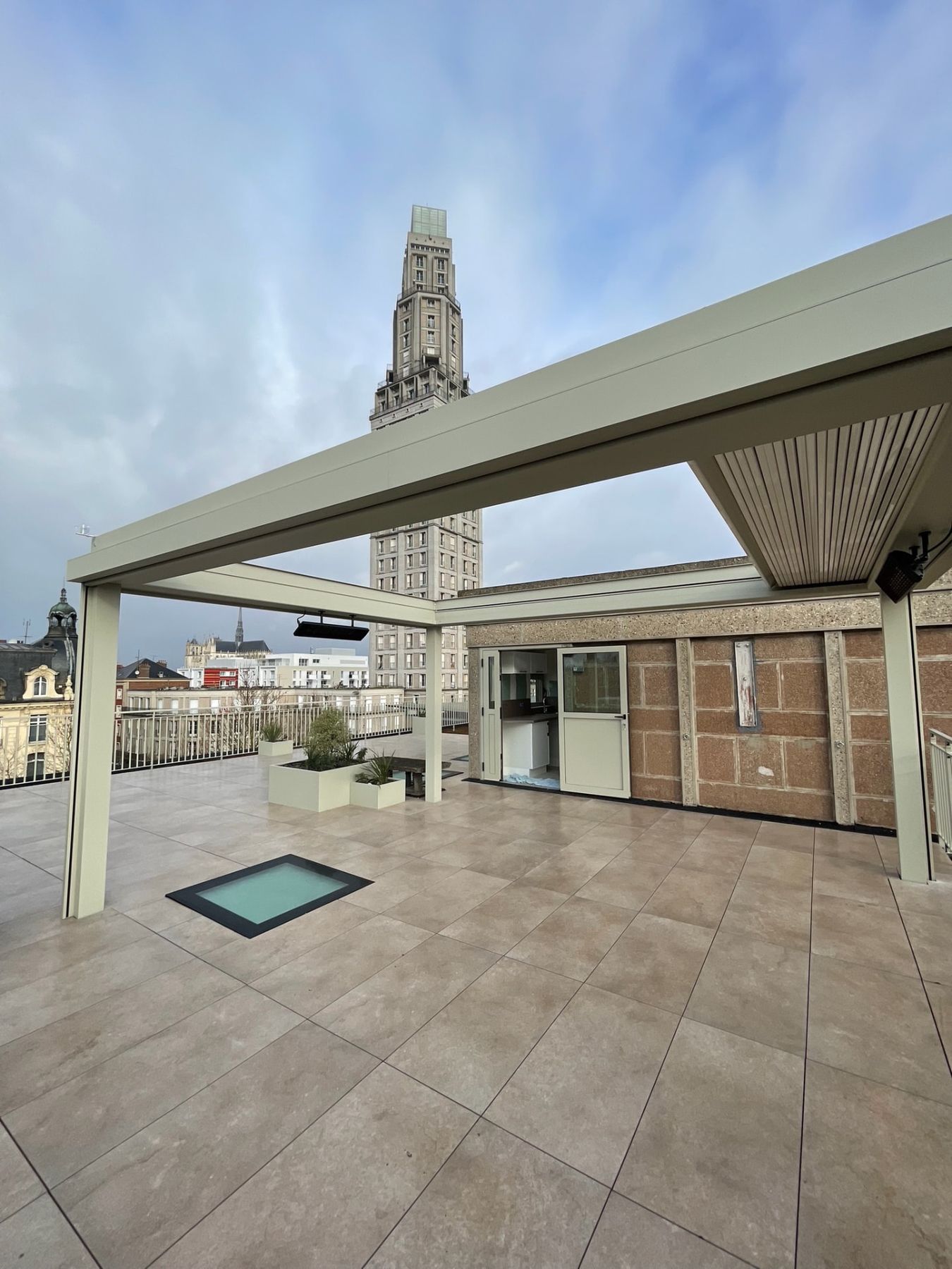 Pergola bioclimatique à lames sur terrasse accessible, Tour Perret en arrière-plan