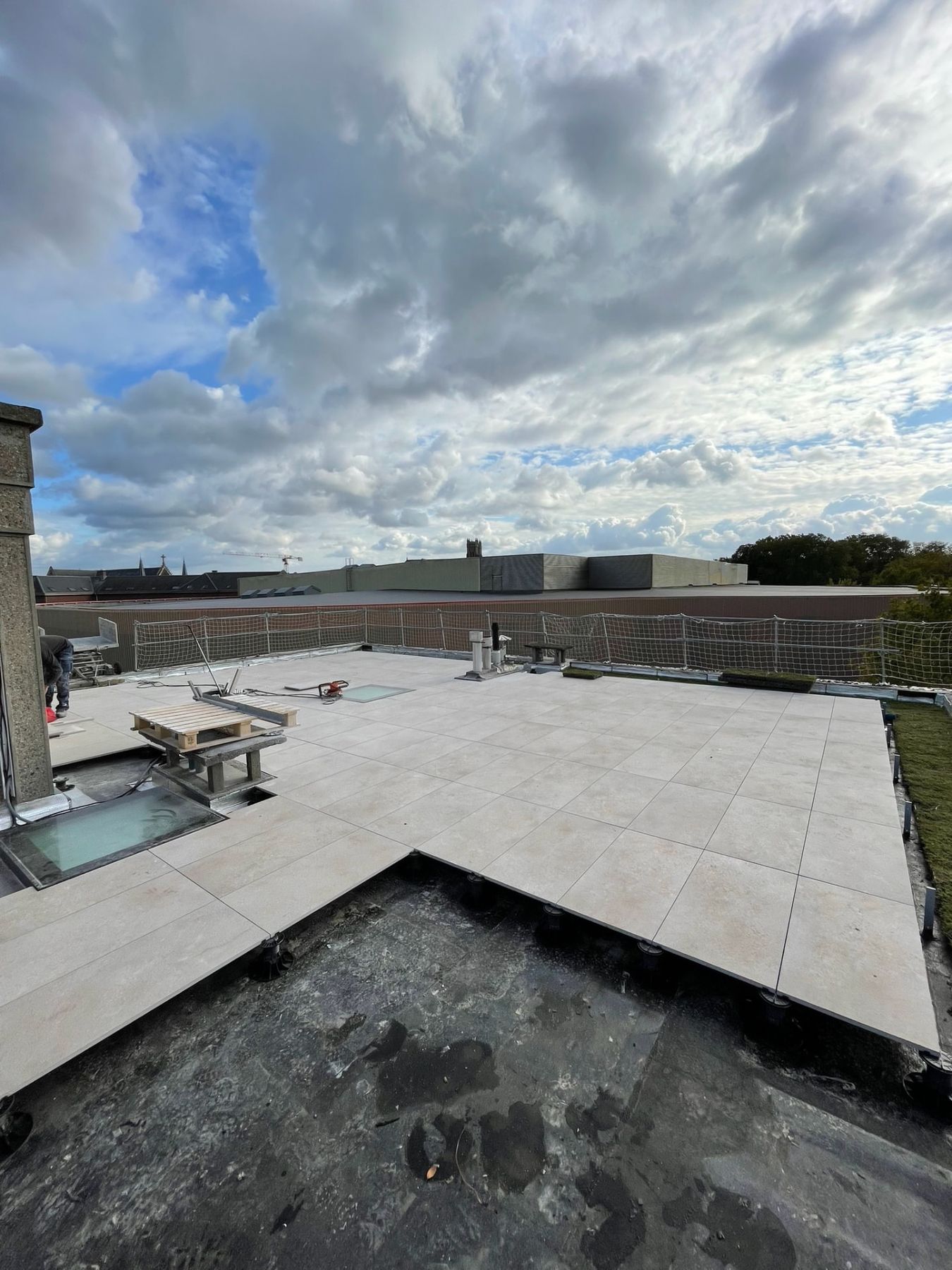 Terrasse sur plots terminée : dalles, étanchéité apparente et bandes végétales