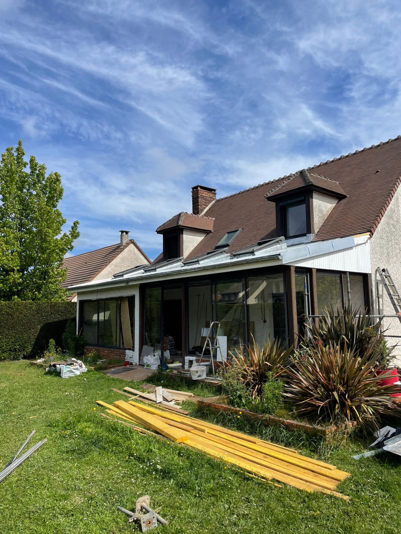 Extension véranda après travaux : toiture zinc neuve avec fenêtres de toit en bandeau