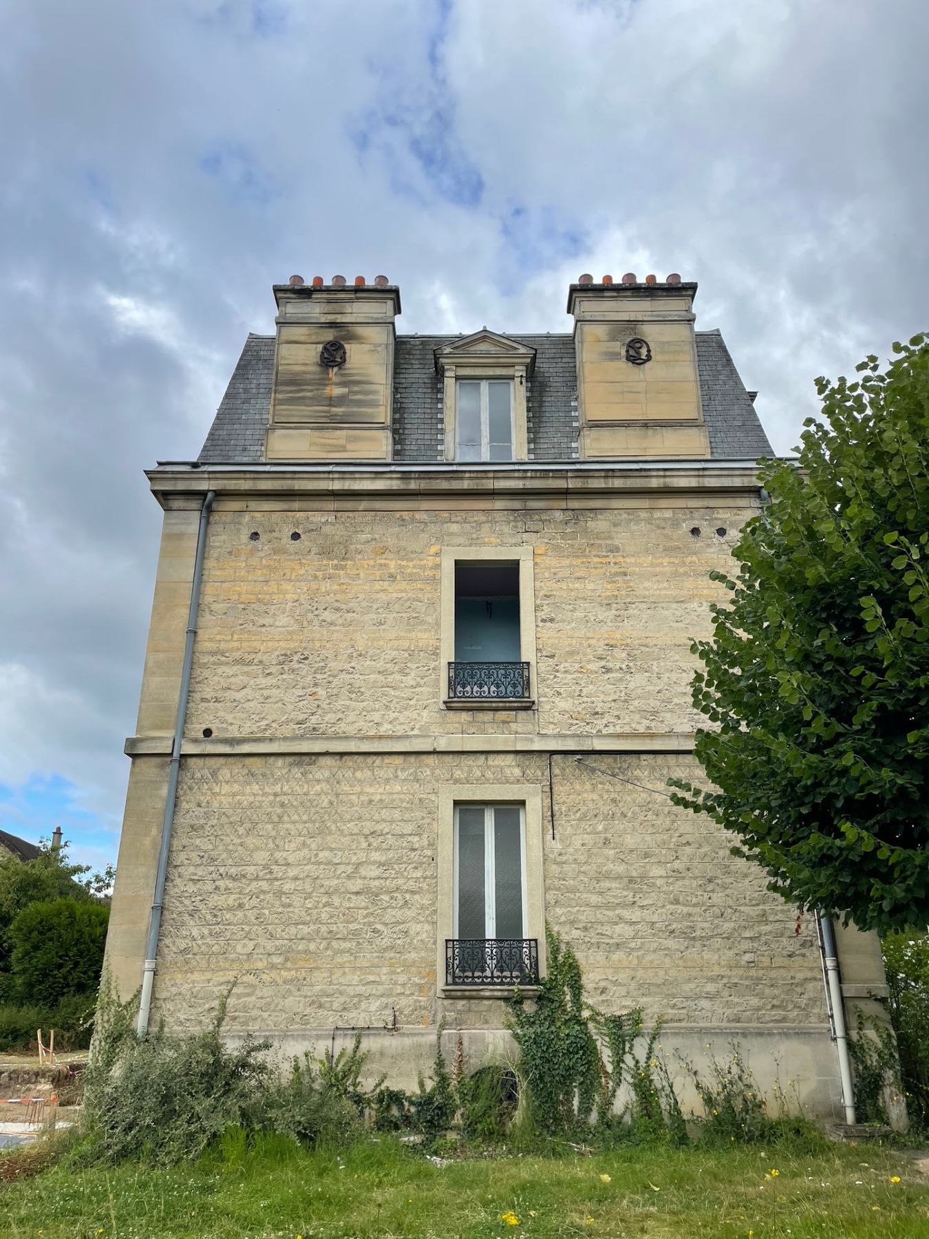 Maison de maître avant rénovation, vue latérale de la toiture en ardoise et des souches de cheminée