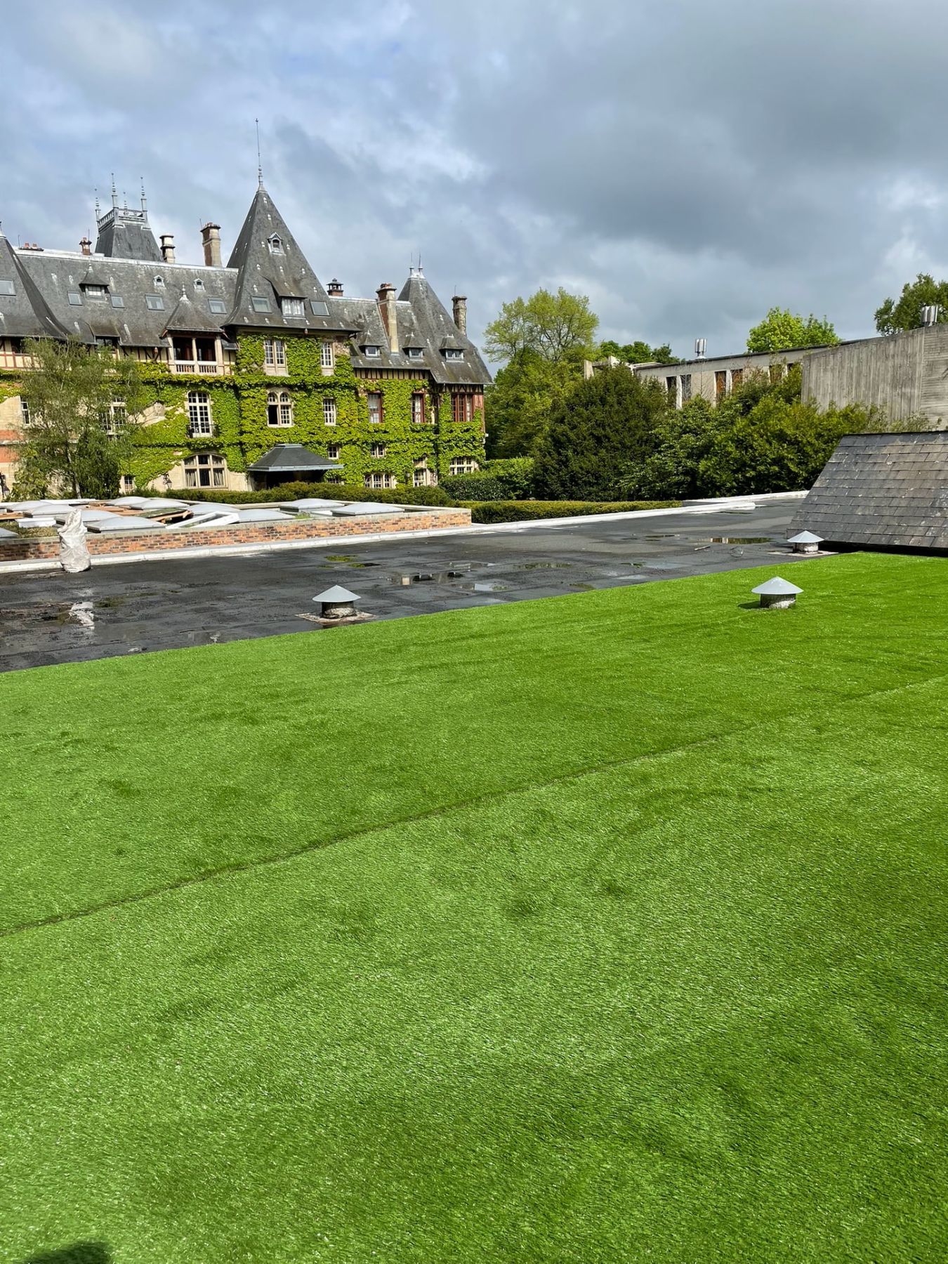 Toiture-terrasse habillée de gazon synthétique, lanterneaux et ventilations conservés