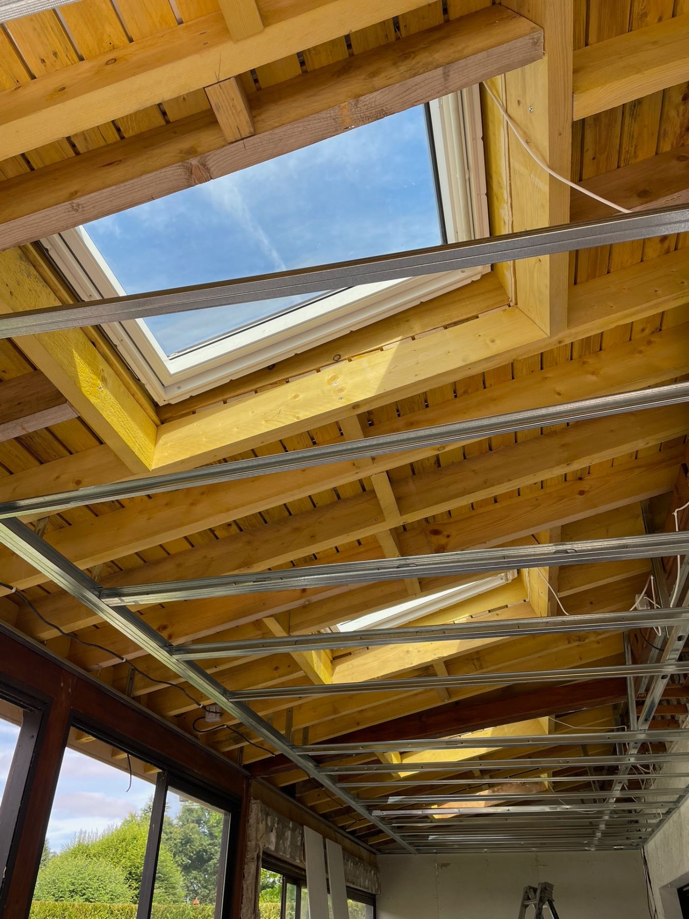 Vue intérieure des fenêtres de toit posées en bandeau pendant les travaux